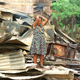 A woman stands in the wreckage of her house, which was destroyed during a FARC attack.